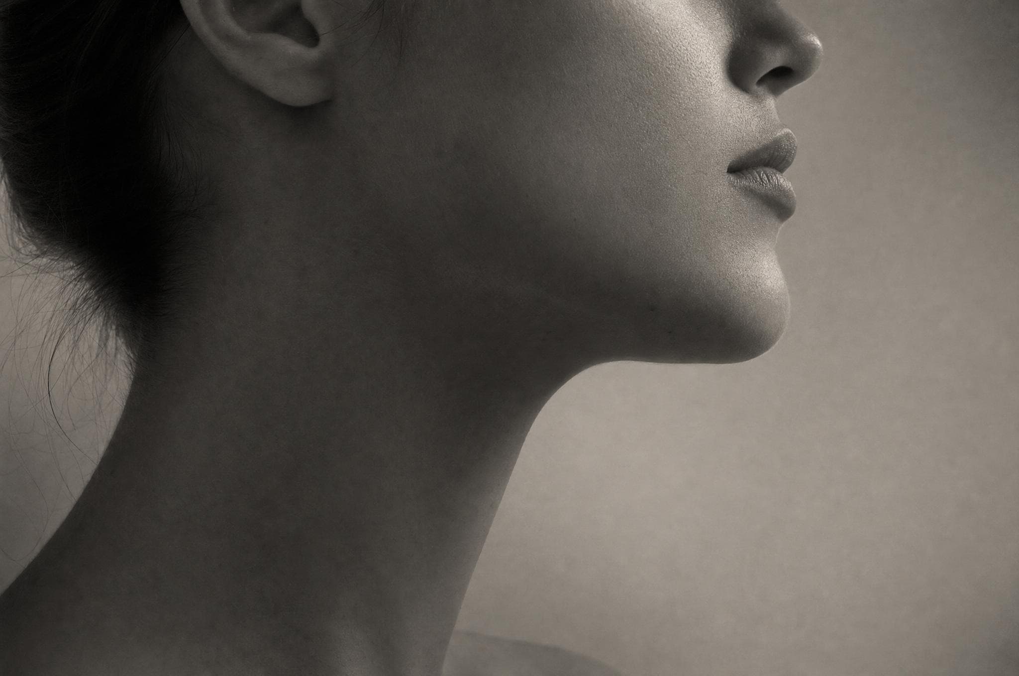 Sculptural study of a jawline and ear in grazing light
